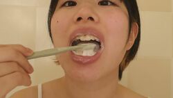 Pure female college student brushes her teeth